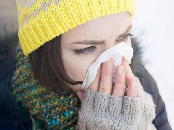 Otrivin-was-ist-eine-Erkältung Frau in Winterkleidung putzt sich die Nase