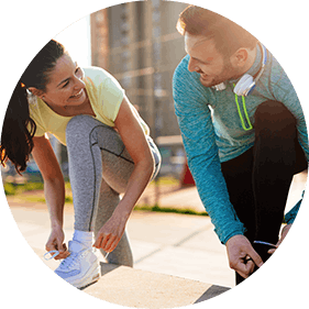 Man and woman in running gear tying shoe laces Man and woman in running gear tying shoe laces