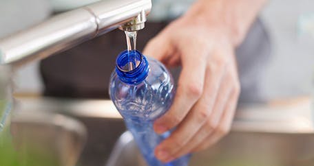 filling up plastic water bottle