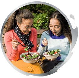 Two women having a snack outdoors Two women having a snack outdoors