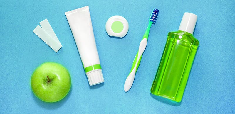 Green apple beside a white and green travel items Green apple beside a white and green travel items