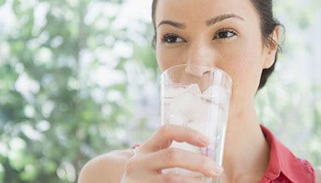 woman drinking a glass of iced water woman drinking a glass of iced water
