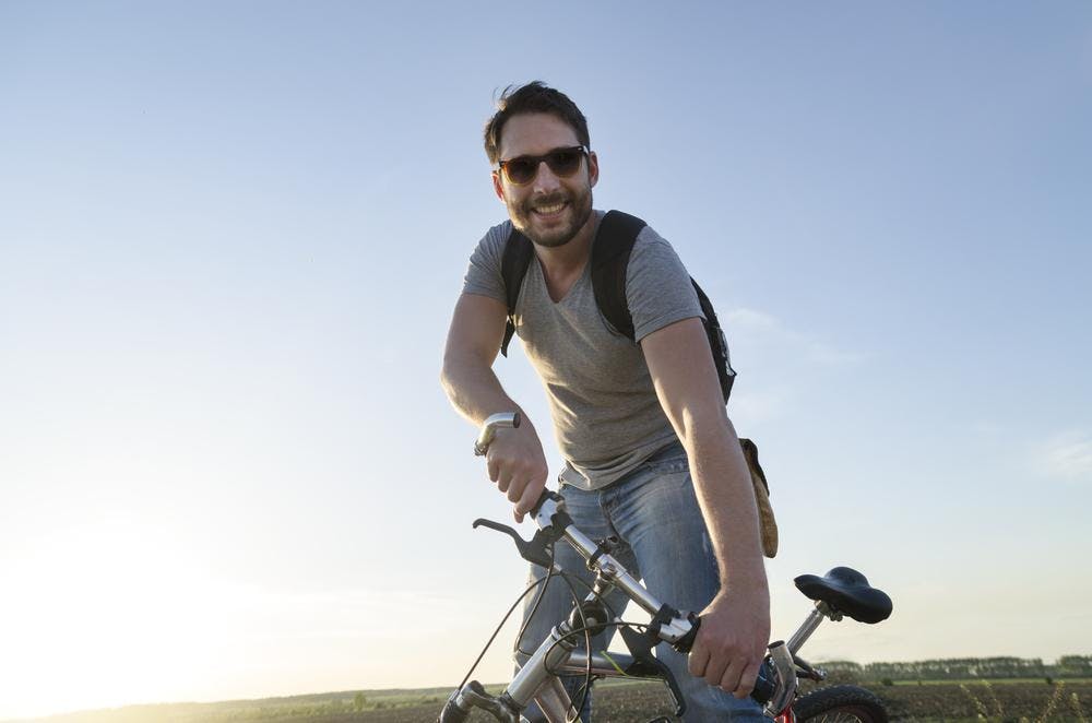 Guy with bike in front of sun Guy with bike in front of sun