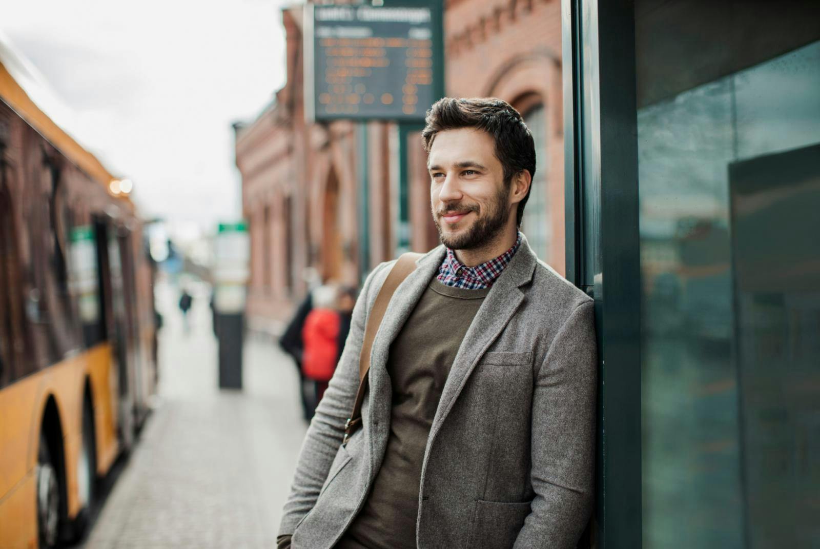 Man with a beard standing casually at a bus stop Man with a beard standing casually at a bus stop