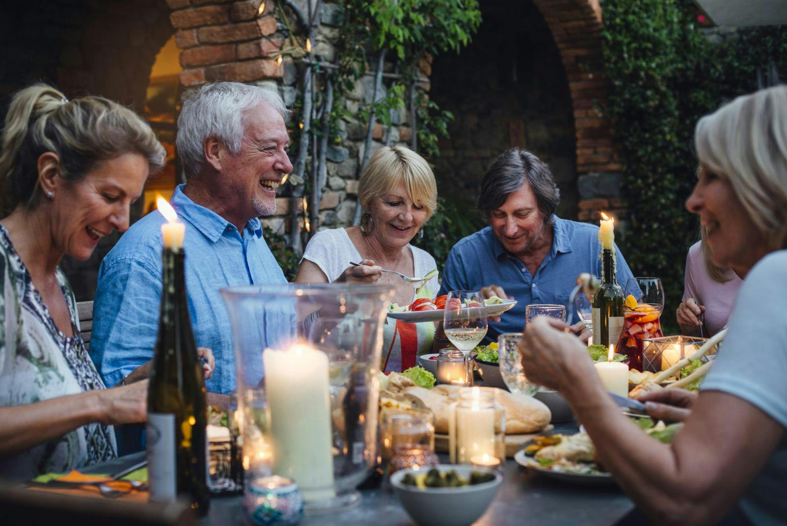 Een groep ouderen die samen aan een tafel zitten te eten.