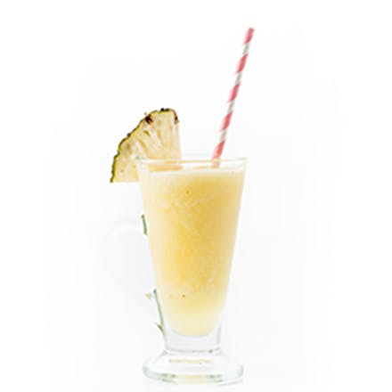 Tropical Medley Smoothie Tropical Medley Smoothie in glass with striped straw and pineapple wedge