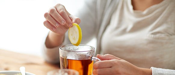 Women Dipping Lemon In Tea Women Dipping Lemon In Tea