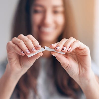 1332759422 Young woman breaking cigarette in half.