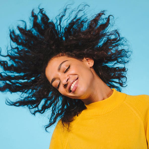 Young woman tossing her healthy hair.