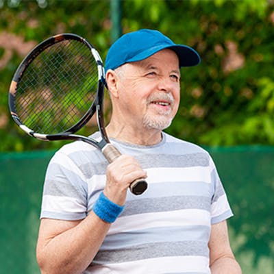 Middle age man playing tennis.