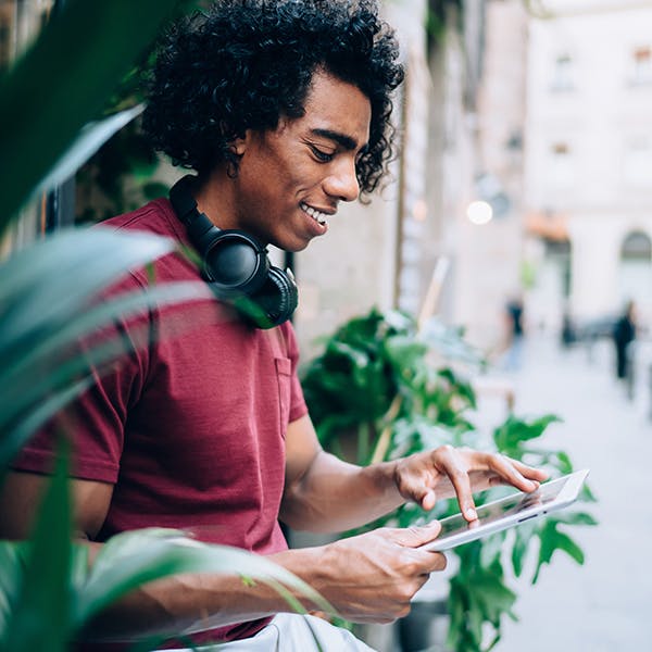 Man standing with headphones and a digital tablet Man standing with headphones and a digital tablet