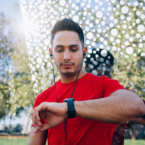 Man with headphones in checking his watch Man with headphones in checking his watch