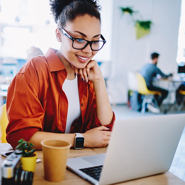 Smiling woman looking at her laptop in a coffee shop Smiling woman looking at her laptop in a coffee shop