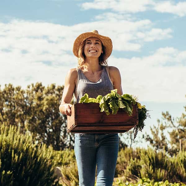 Mujer sujetando una cesta con producto verde Mujer sujetando una cesta con producto verde