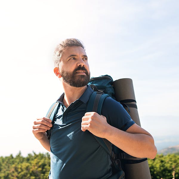 Man with a backpack hiking outside Man with a backpack hiking outside