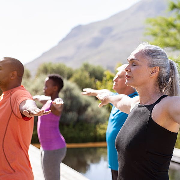 Group of people stretching outdoors Group of people stretching outdoors