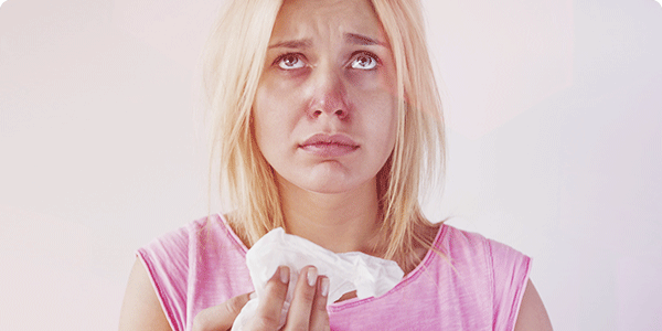 Femme dont le nez est rouge et congestionné Femme dont le nez est rouge et congestionné
