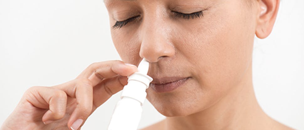 Woman using a nasal spray