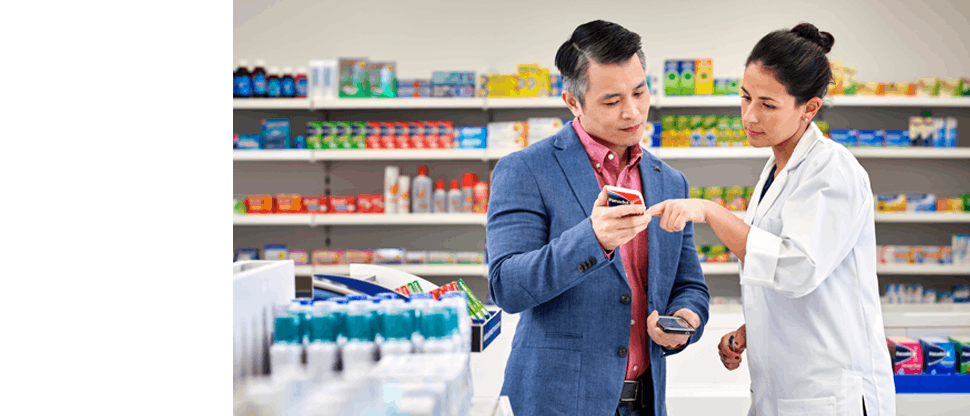 Apothekerin mit Kunde bei Erklärung eines Produkts