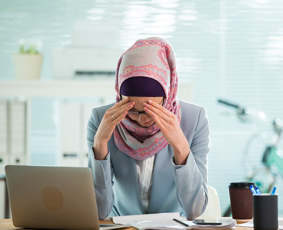 امرأة تعمل وتشعر بصداع شديد امرأة تعمل وتشعر بصداع شديد