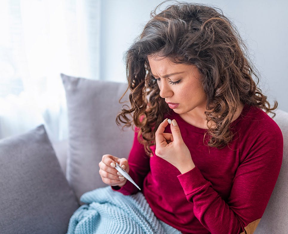 A woman suffering from a headache and an increase of body temperature A woman suffering from a headache and an increase of body temperature