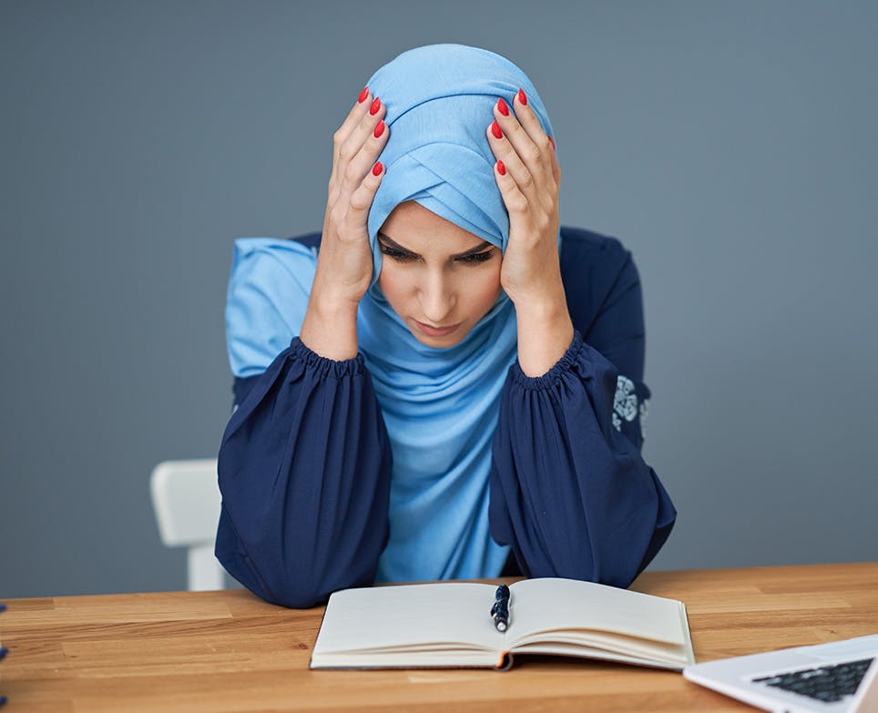 A woman reading and dealing with a headache A woman reading and dealing with a headache
