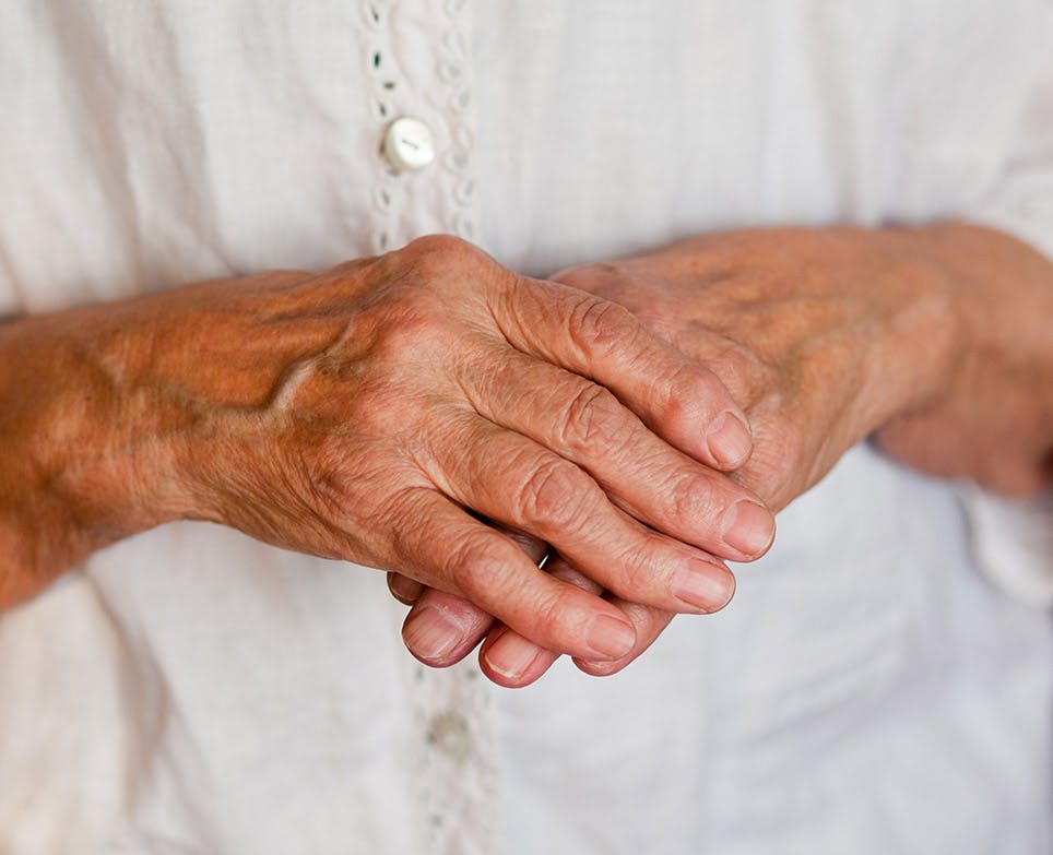 An old woman's right hand holding her left hand An old woman's right hand holding her left hand