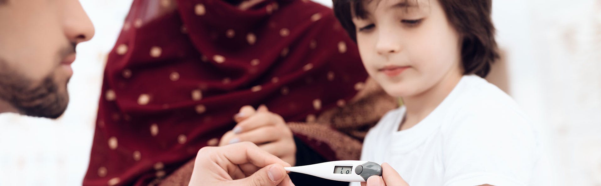 A doctor checking a kid's temperature A doctor checking a kid's temperature