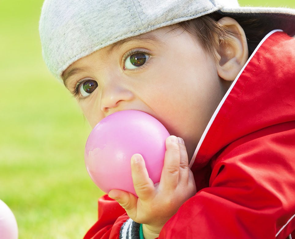 A baby putting a ball in his mouth A baby putting a ball in his mouth