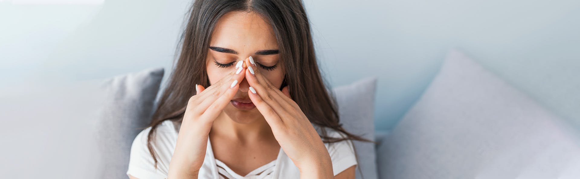 Young woman grabbing her nose to relief the pain. Young woman grabbing her nose to relief the pain.