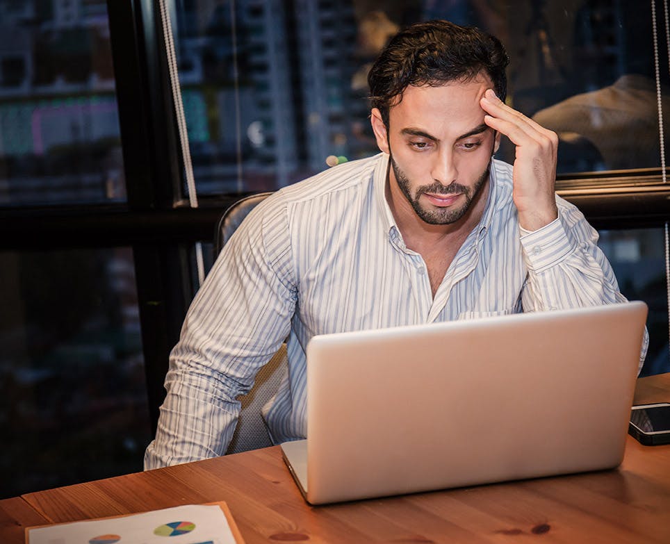 Man in front of a laptop with a headache. Man in front of a laptop with a headache.