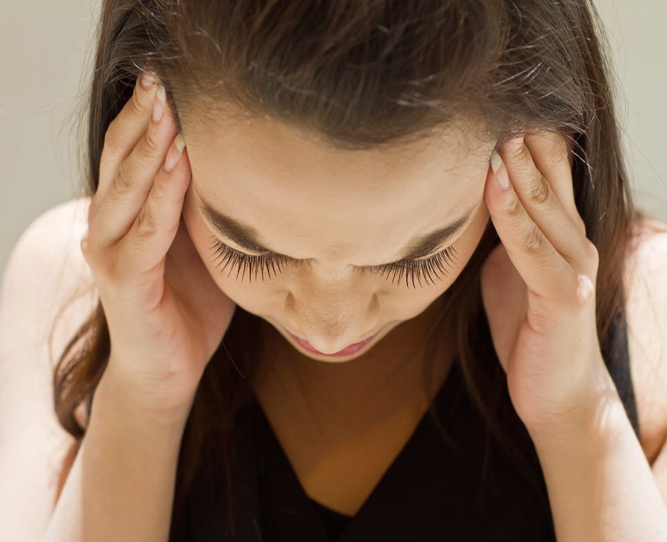Woman holding her head from the sides because of the pain. Woman holding her head from the sides because of the pain.