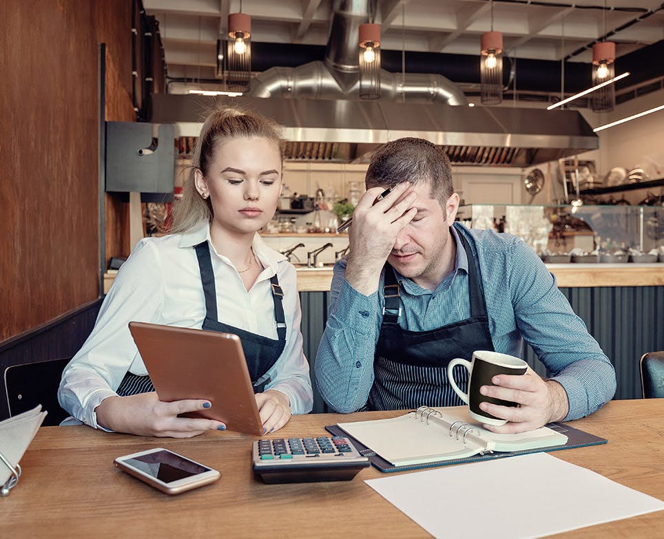 A couple working. The man holds his aching head. A couple working. The man holds his aching head.