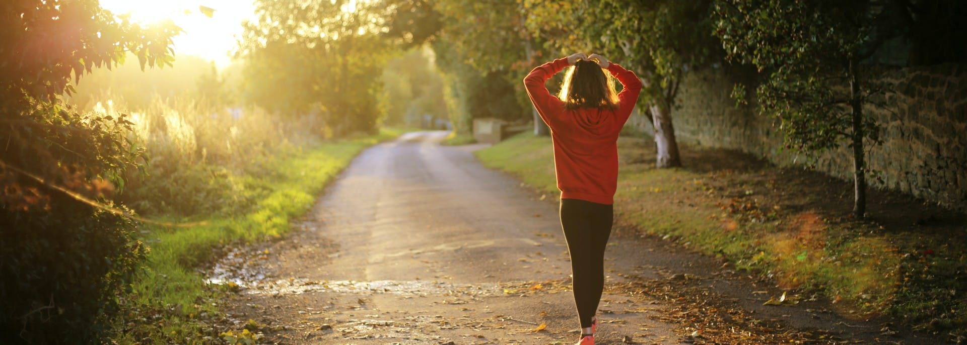 Girl in red sweater walking on path through park