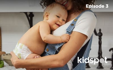 Mother in overalls hugging her baby in nappy