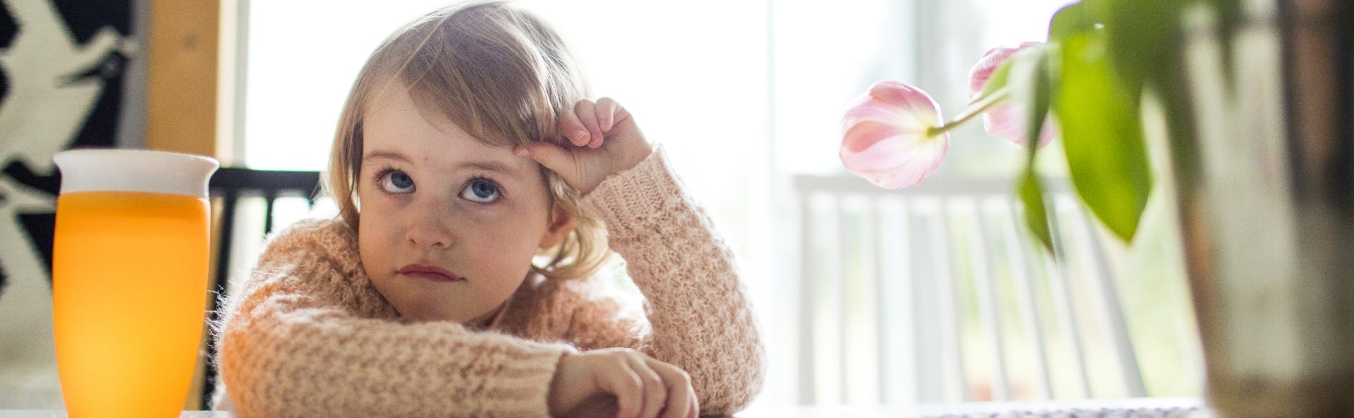 Kid sitting at dining table looking bored