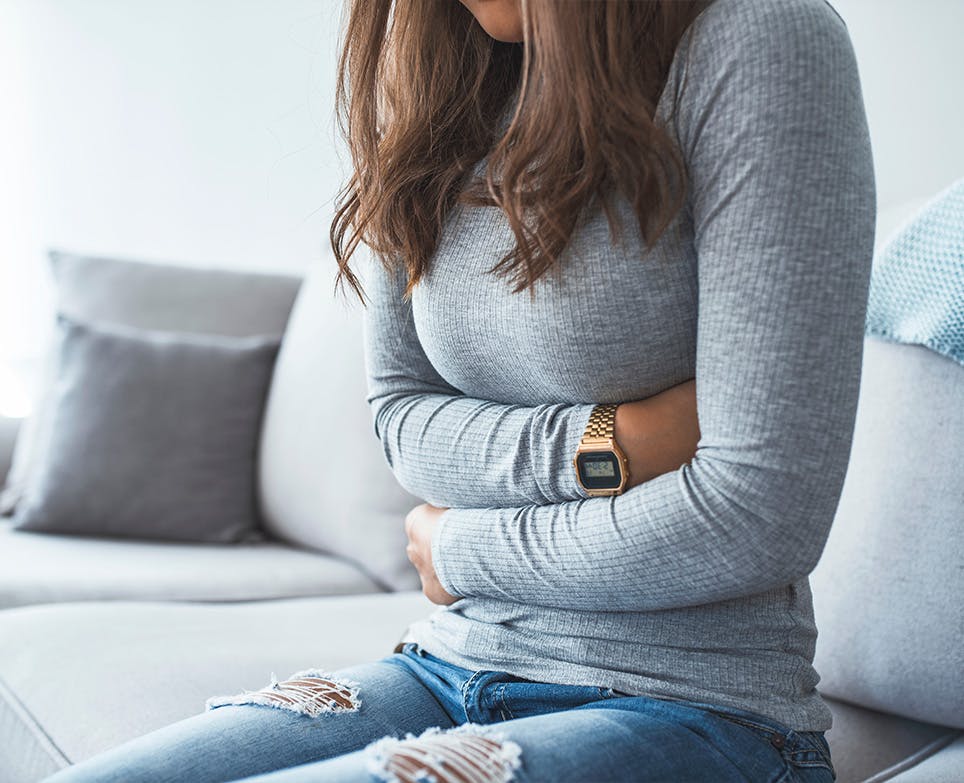 Mujer tocándose el vientre bajo con las dos manosen señal de dolor. Mujer tocándose el vientre bajo con las dos manosen señal de dolor.