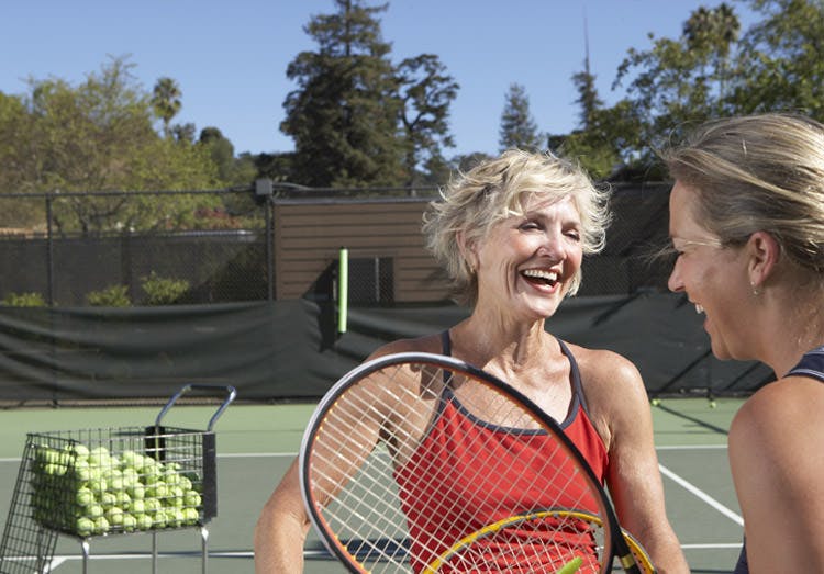 Women talking over a tennis game Women talking over a tennis game