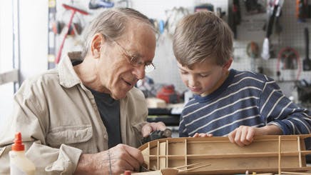 Caucasian Man And Grandson Working On Model Ship Caucasian Man And Grandson Working On Model Ship