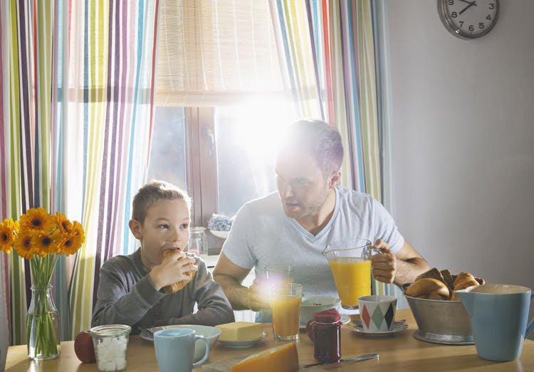 Father And Son Sitting At Breakfast Table Father And Son Sitting At Breakfast Table