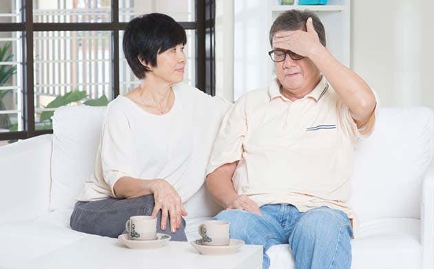 Senior Woman Caring For Man With A Fever Senior Woman Caring For Man With A Fever