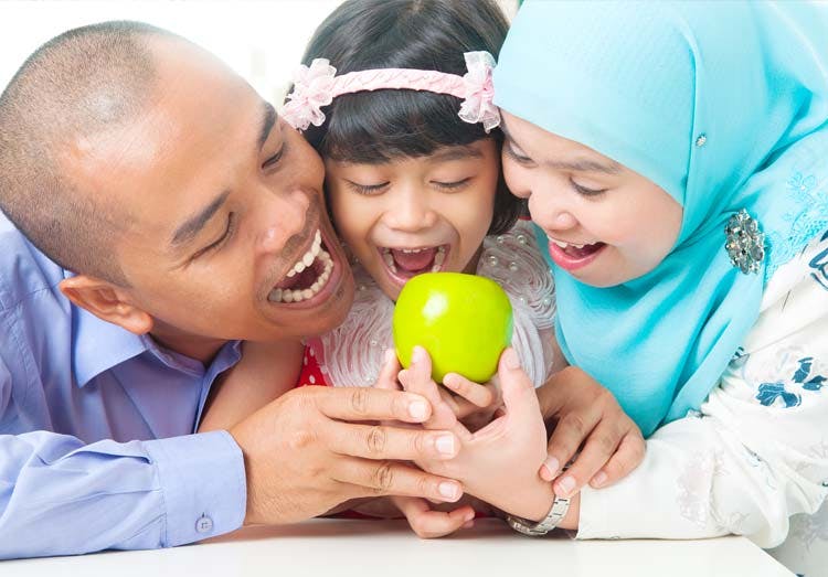 Father, mother and daughter getting ready to bite an apple Father, mother and daughter getting ready to bite an apple