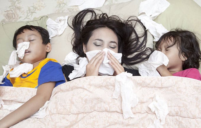 Mother, son and daughter sick in bed with flu Mother, son and daughter sick in bed with flu