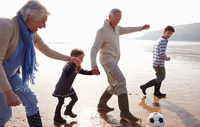 Abuelos jugando fútbol en la playa con sus nietos. Abuelos jugando fútbol en la playa con sus nietos.