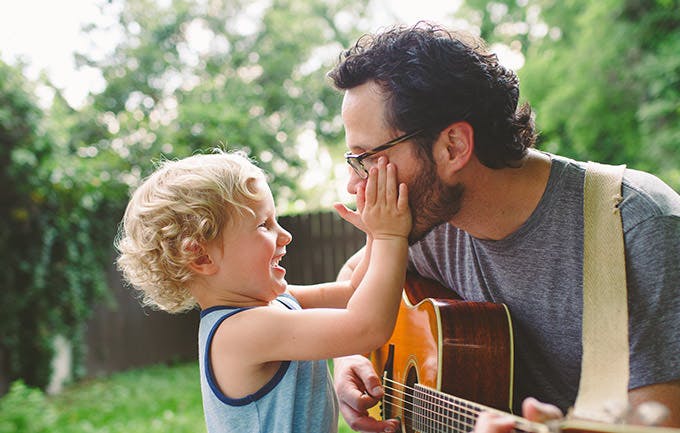 Pai toca guitarra para o seu filho