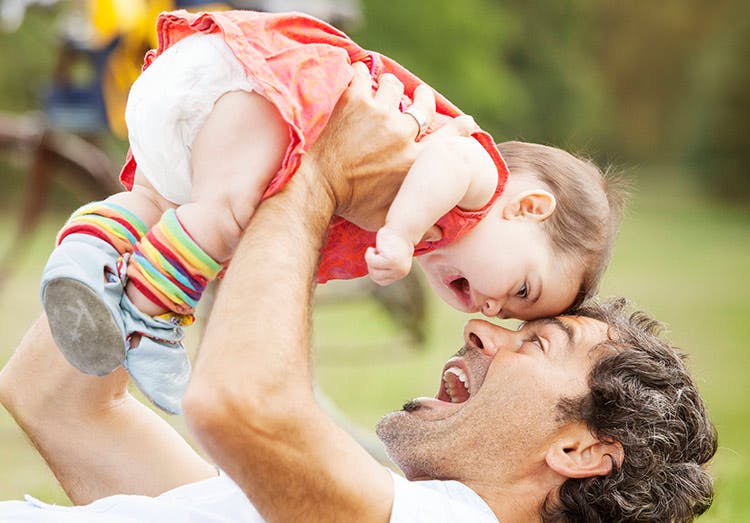 Pai brinca com a sua filha no parque