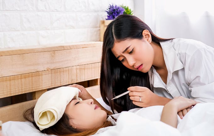 Young woman taking her temperature Young woman taking her temperature