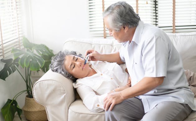 Senior Woman Caring For Man With A Fever Senior Woman Caring For Man With A Fever