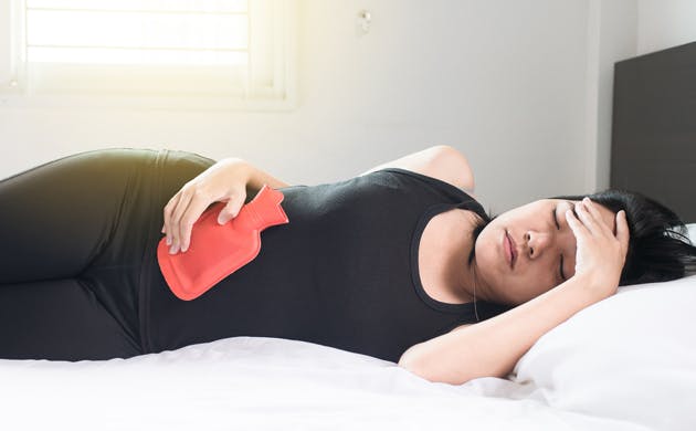 Woman experiencing abdominal pain Woman experiencing abdominal pain