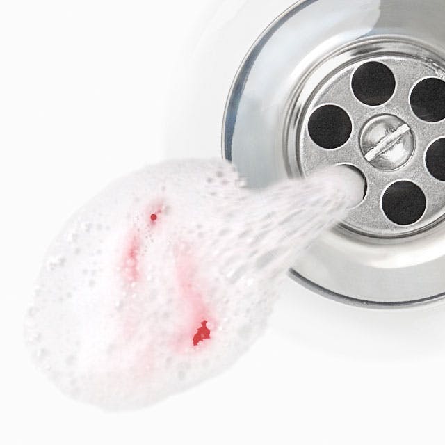 Spit with blood in a sink drain Vyplivnutá pasta, ve které je vidět krev